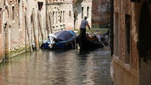Gondola in a narrow canal ging around the corner in Venice Italy