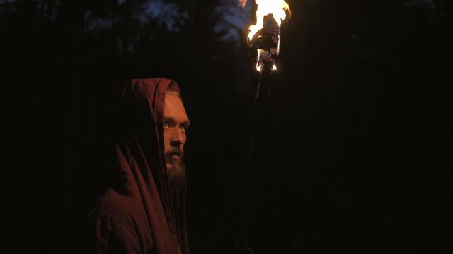 Man in monastic robe with burning torch
