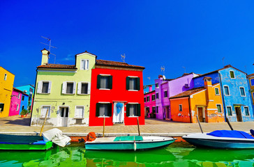 Fototapeta na wymiar View of the colorful Venetian houses along the canal at the Islands of Burano in Venice.