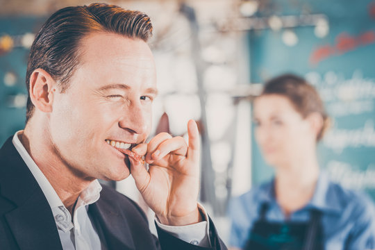 in der Metzgerei oder Fleischerei,  Verk&auml;uferin und Kunde, der Kunde probiert die Salami