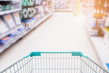 Shopping cart with garden equipment in Supermarket aisle defocused blurred background