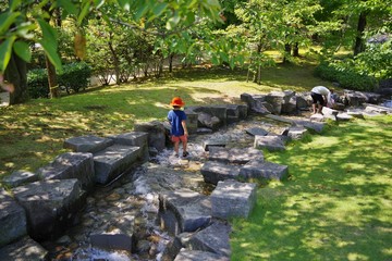 夏の公園で水遊びをする子供