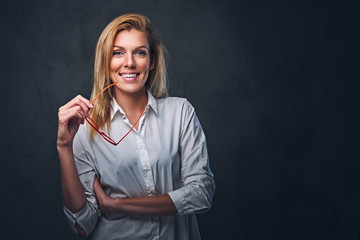 Blond female dressed in a white shirt and red eyeglasses.