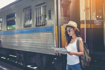 Happy women tourist on map to railway station vacation.Travel concept.