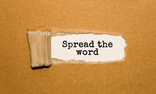 The text Spread the word appearing behind torn brown paper