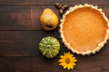 pumpkin homemade pie at wooden background arranged with food ingredients top view