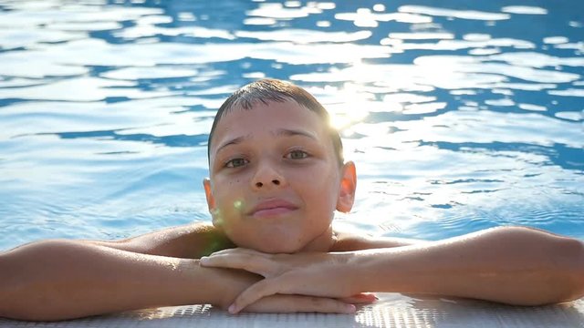 A happy seven-year-old  boy keeps the edge of the sea coast being in playful water, and enjoying his life in slow motion. The seascape id great and gorgeous