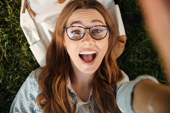 Close up top view of happy brunette woman in eyeglasses