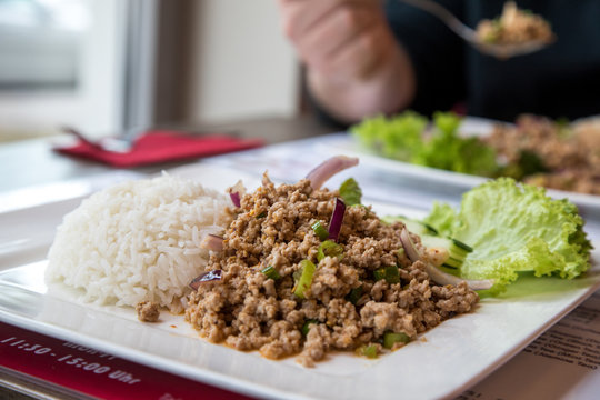 Mann isst Laab Moo Thai-Salat mit Hackfleisch mit Reis 