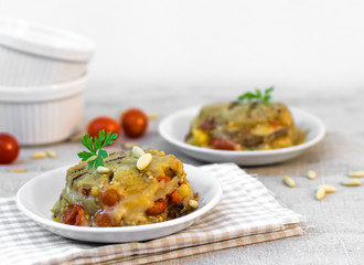 Homemade little cakes with aubergines, tomatoes, pine nuts and cheese. Mediterranean diet with summer vegetables. Italian healthy food.