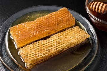 Honey and honeycomb on black dish