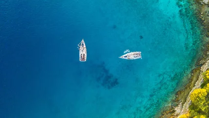 Cercles muraux Naviguer Aerial view of two sailing boats anchoring next to reef