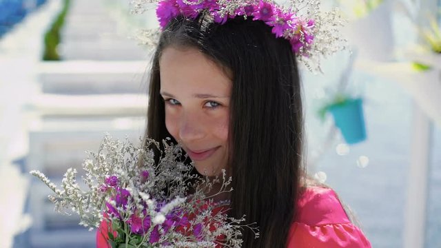 Close-up of girl smiling and sniffing the flowers. Slowly