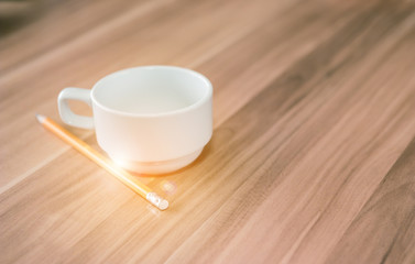 Coffee cup white paste with a pencil on the desk of an engineer.