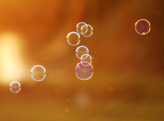 festive background with iridescent soap bubbles flying towards the sun