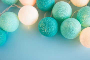 Blue and white light ball made of yarn threads closeup on the blue background, top view. Christmas decorations.