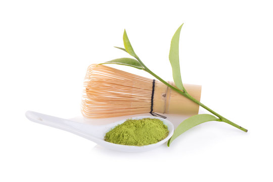 matcha powder in White ceramic spoon and whisk isolated on white background