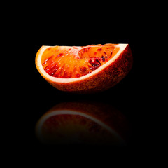 Part of red sicilian orange isolated on black background