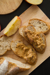 French bread baguette cut on wooden board with knife. with a chocolate butter