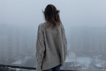 Dramatic photo of model on roof with fog