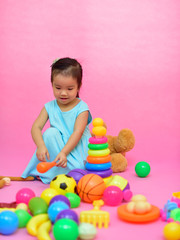 Obraz premium Cute Asian girl playing toys in living room 