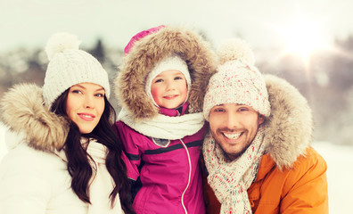 happy family with child in winter clothes outdoors