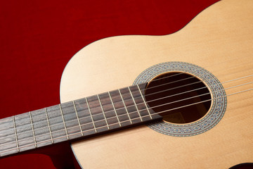 acoustic guitar on red velvet fabric, closeup object