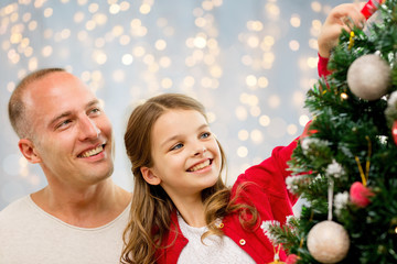 father and daughter decorating christmas tree