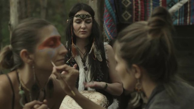 ethno group, they dancing and playing drums and doing makeup