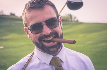 Portrait of smiling golfer with cigar with driver