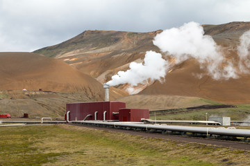 Fototapeta na wymiar Geothermal power station in Iceland. Generation of ecologically clean renewable energy. Landscape of geothermal sources and geothermal energy plant.