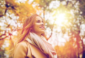 Naklejka premium beautiful happy young woman walking in autumn park