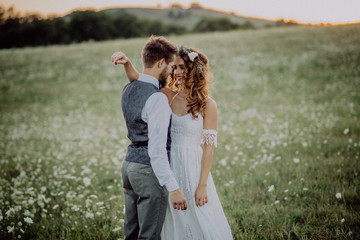 Beautiful bride and groom at sunset in green nature.