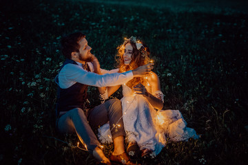 Beautiful bride and groom on a meadow at night.