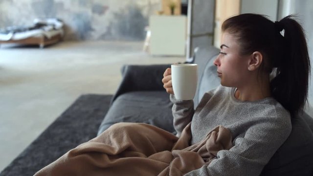Exhausted brunette enjoying her cup of aromatic tea