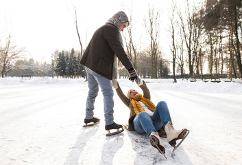 Senior couple in sunny winter nature ice skating.