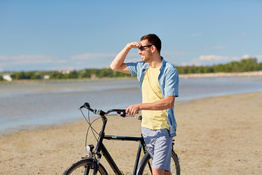 happy man with bicycle on summer beach