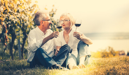 Senioren Paar genießt Rotwein draußen, Mann und Frau posten einander zu