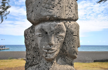 Stone statue, black sand beach, Reunion Island, France