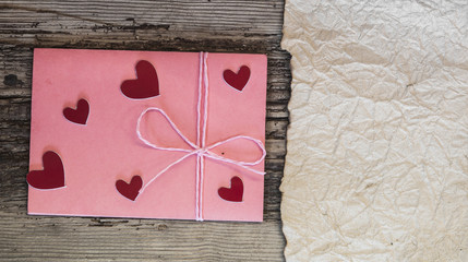 pink envelope and little heart on wood table for Valentines Day