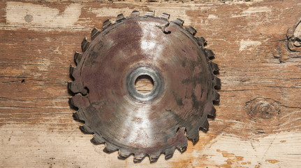 Metal saw blade on a wooden background