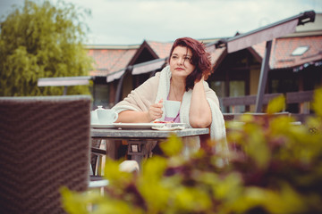 Plump nice american middle age simple woman sit in cafe on a terrace at warm autumn day and enjoy the life, have cozy mood