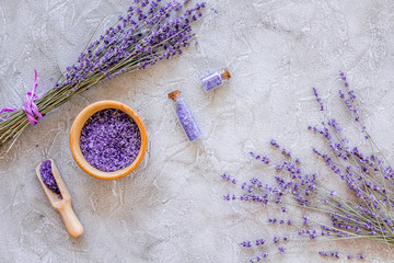 cosmetic set with lavender herbs and sea salt in bottle on stone table background flat lay