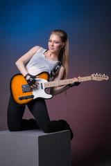 Obraz premium Girl with guitar at the rehearsal before the performance