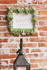 Instagram sign with floral frame on a brick wall