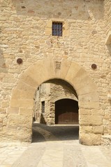 Fototapeta na wymiar Medieval stone arch in the medieval village of Pals, Girona, Spain