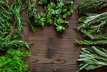 drying fresh herbs and greenery for spice food on wooden kitchen desk background top view space for text