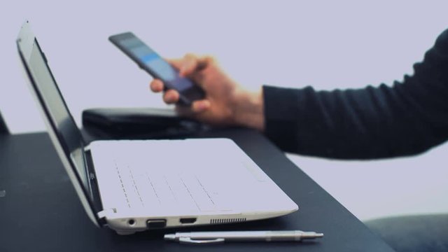 A man (Man's hands), an office worker, sits at home outside his time using a laptop and a bank credit card, pays for online payment in an online store.