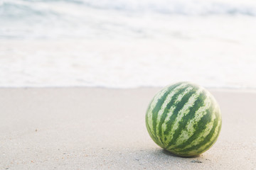 Fototapeta na wymiar watermelon on the beach with a knife by the sea