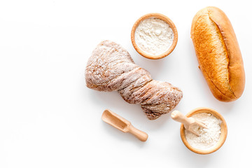 fresh bread with wheat flour in bakery shop on white desk background top view mock up